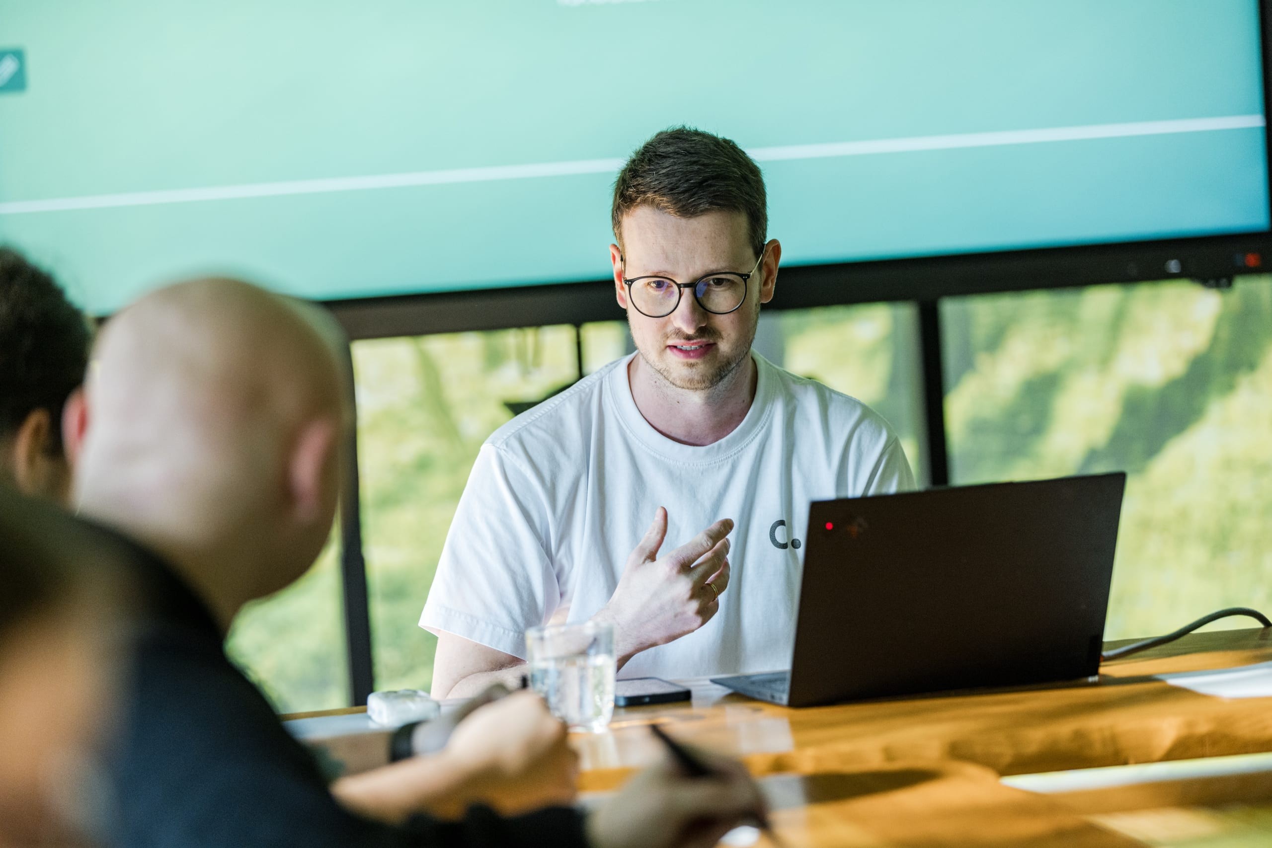 Conciso-Kollege erläutert im Meeting am Laptop einen Arbeitsablauf