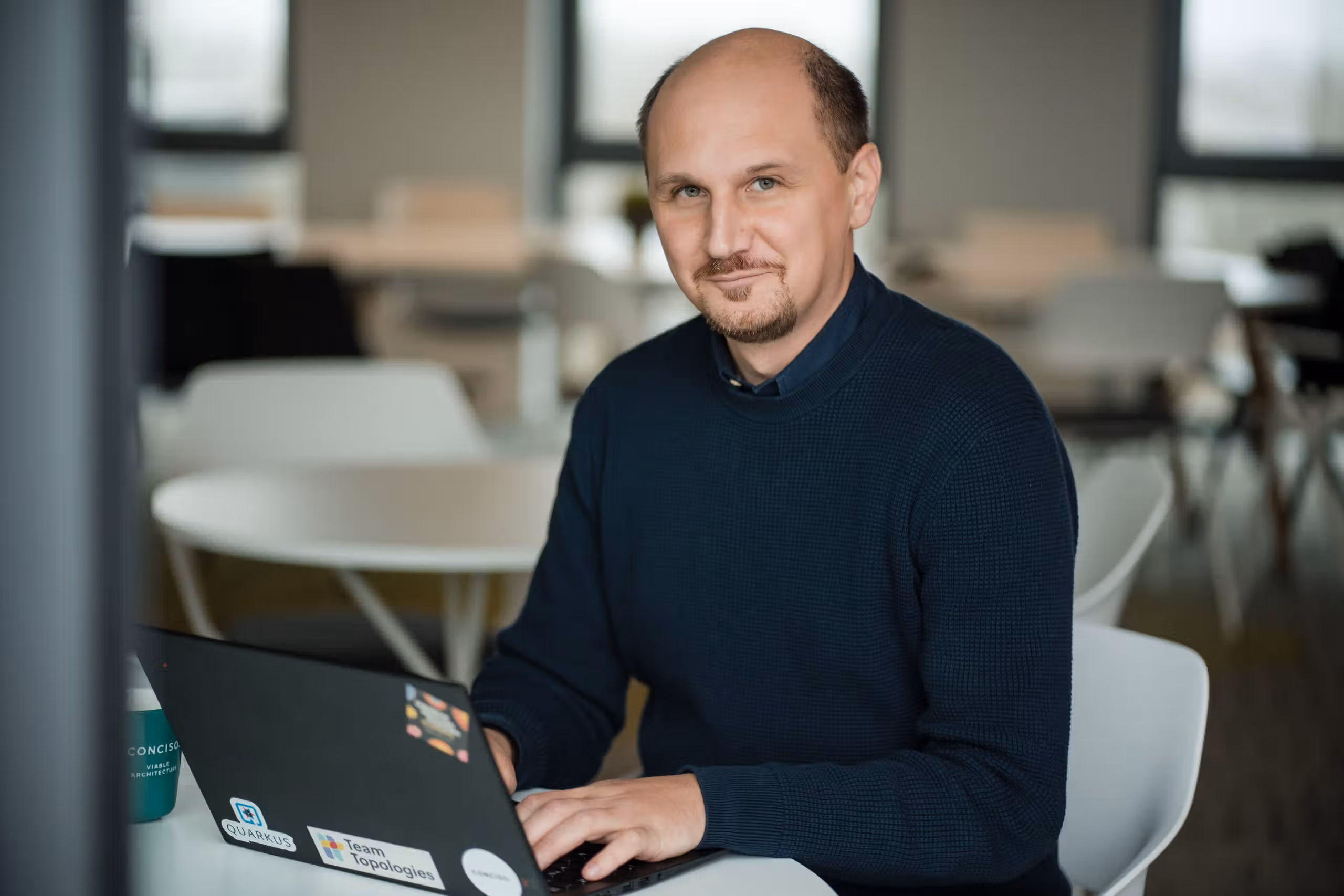 Sven-Torben Janus, lächelnd am Laptop im Conciso-Büro