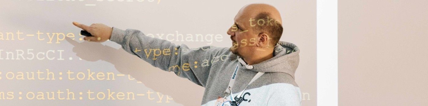 Sven-Torben Janus zeigt bei einem Vortrag auf eine Projektion mit Keycloak-Token-Konfiguration