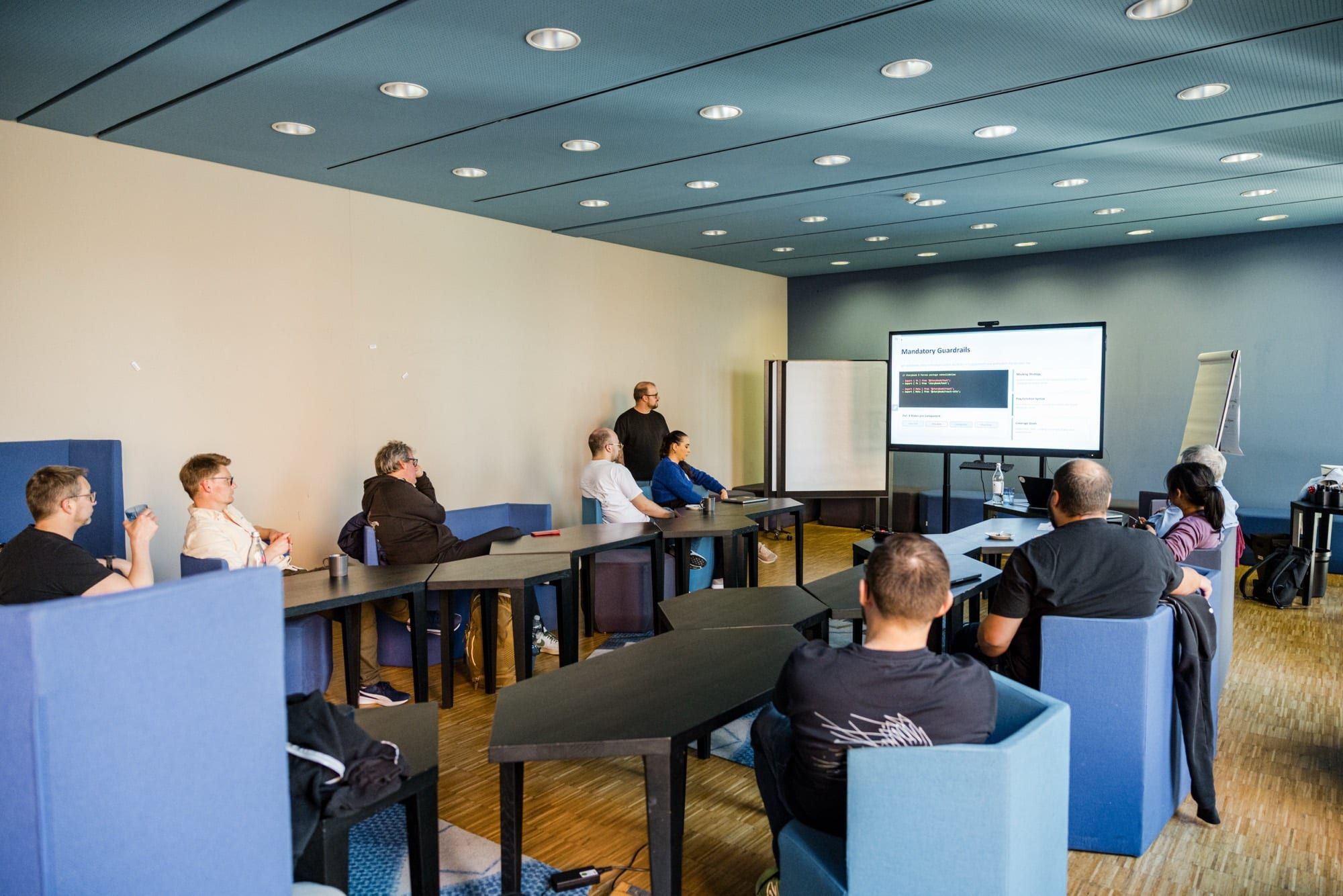 Trainer:in vor einer Gruppe in einem Trainingsraum