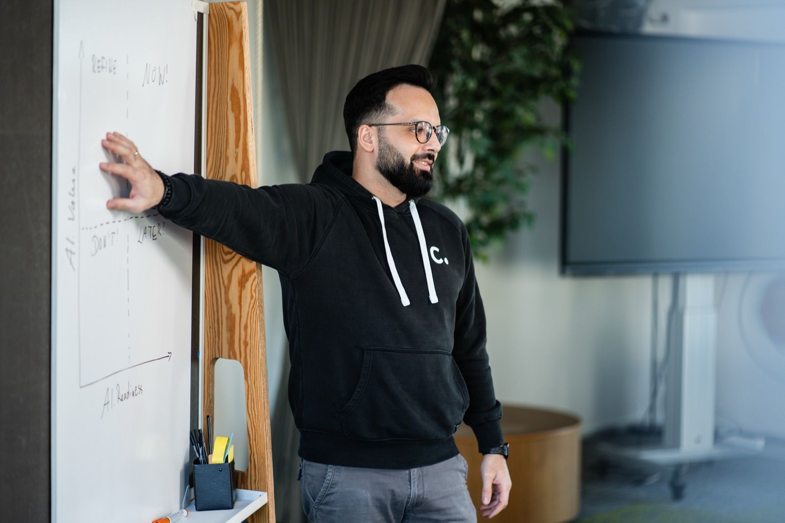 Person erläutert eine Strategie-Matrix an einem Whiteboard