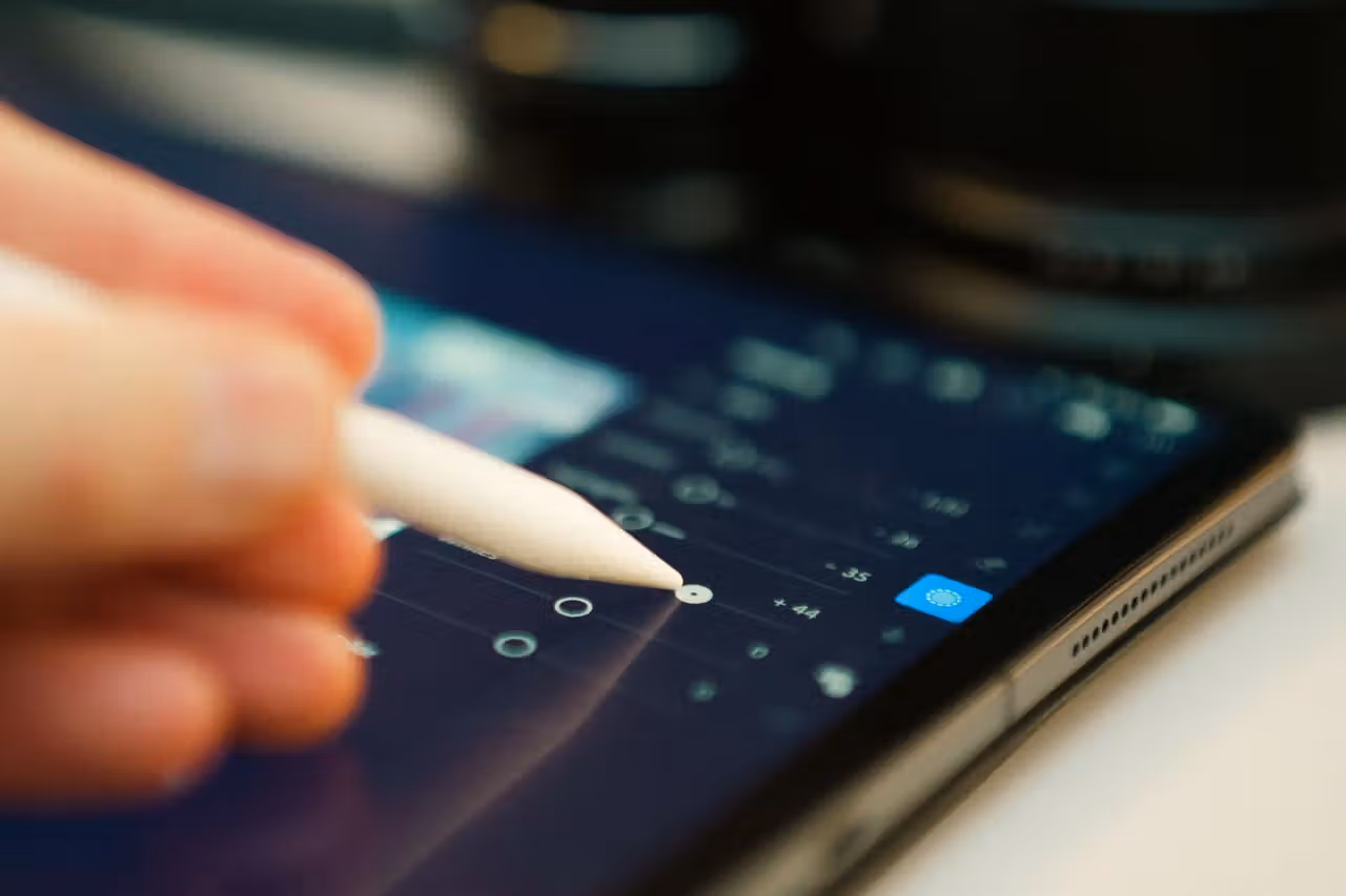 Eine Hand stellt mit einem Eingabestift Regler auf einem Tablet-Bildschirm ein