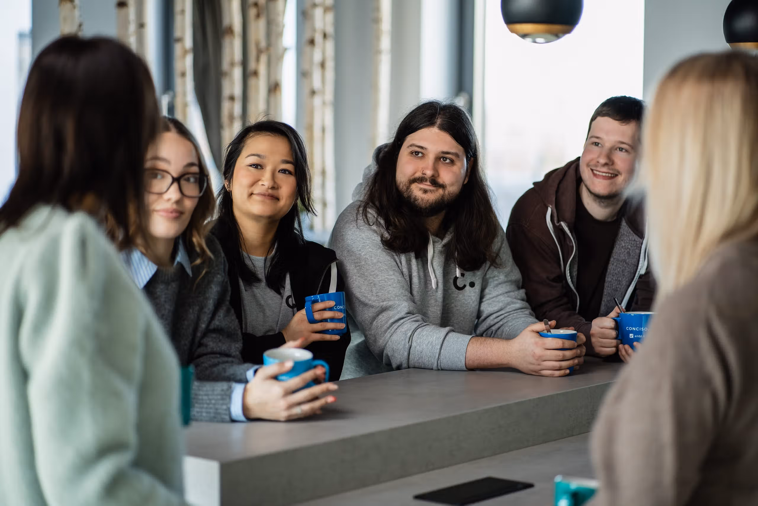 Conciso-Team mit Kaffeetassen im Gespräch