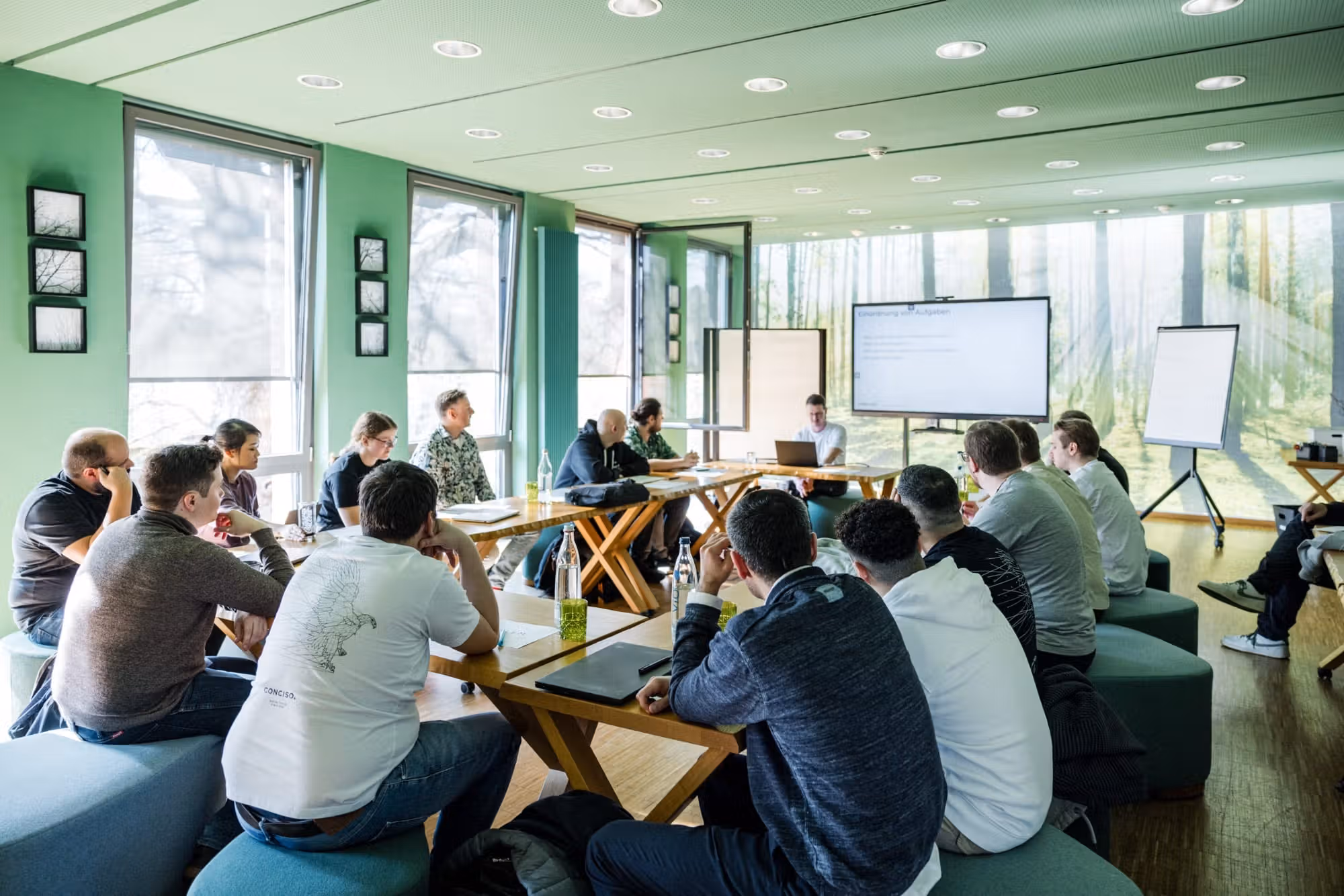 Team diskutiert an einer mit Notizen beklebten Wand